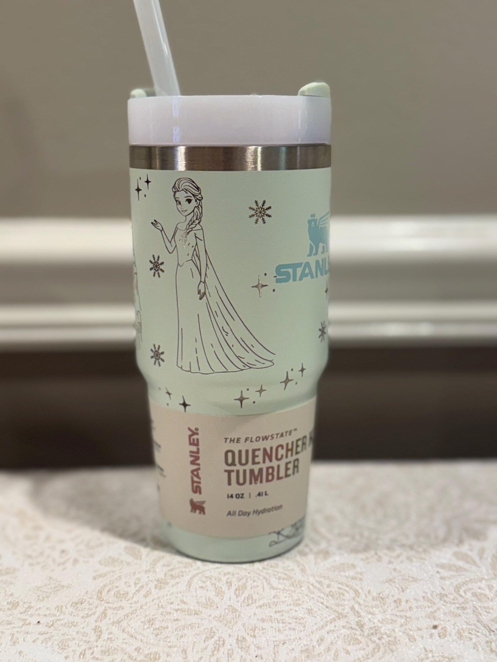Stanley tumbler with a character design on a neutral background