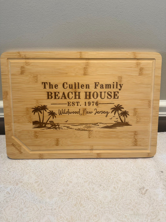 Bamboo cutting board with engraved text and beach scene design on a neutral background