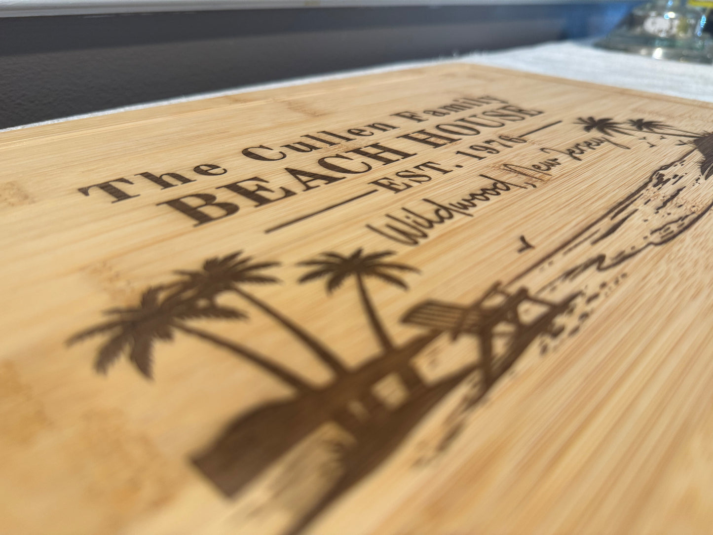 Wooden sign with engraved text and palm tree design on a wooden surface.
