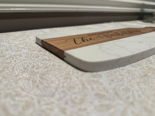 Wooden and marble cutting board with 'The Table' engraving on a marble surface.