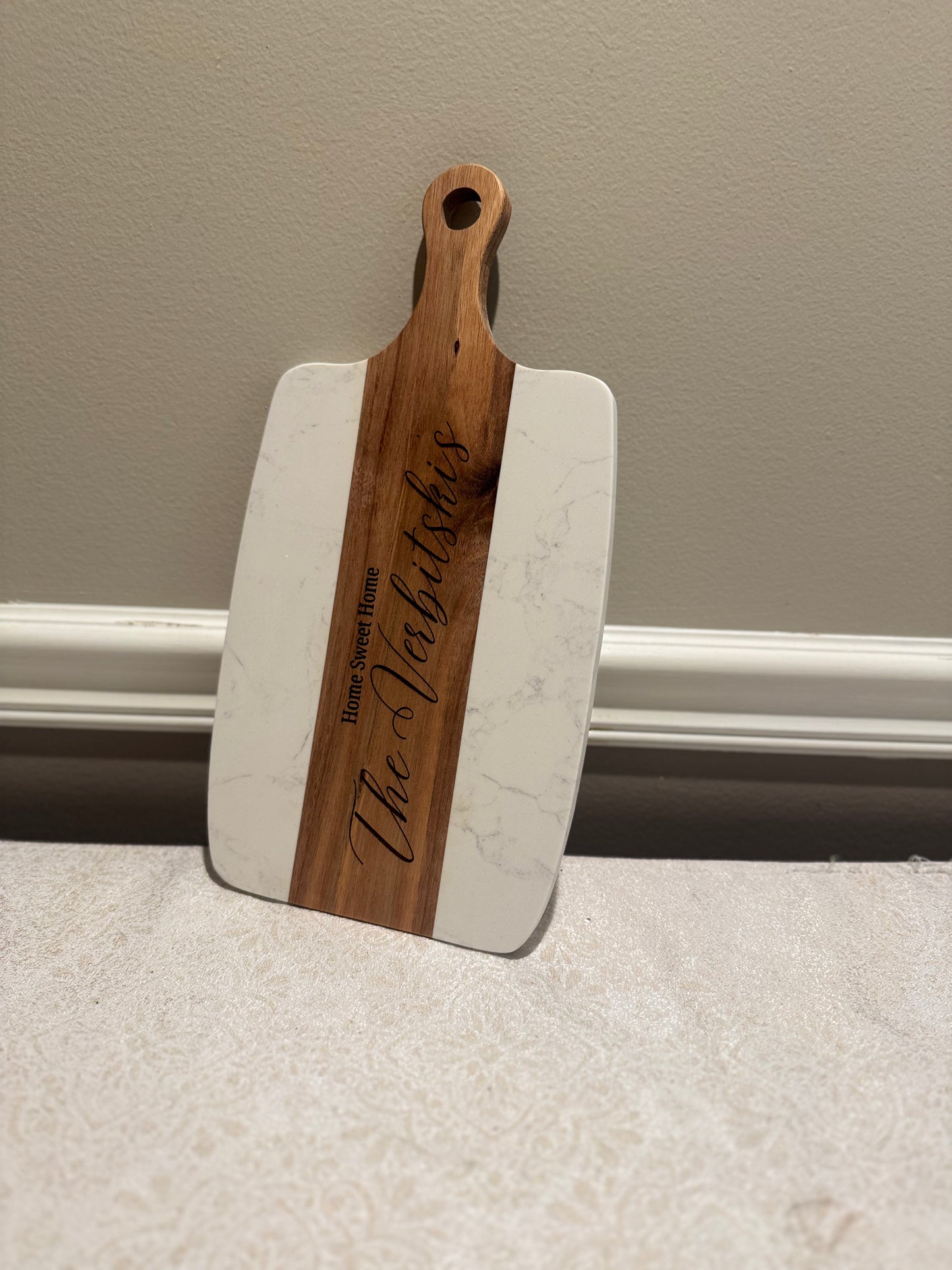 Wooden and white cutting board with 'The Valdichies' engraving on a neutral background