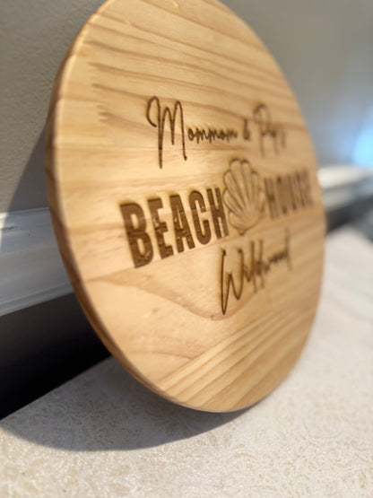 Wooden coaster with 'Beach House' engraving on a light surface