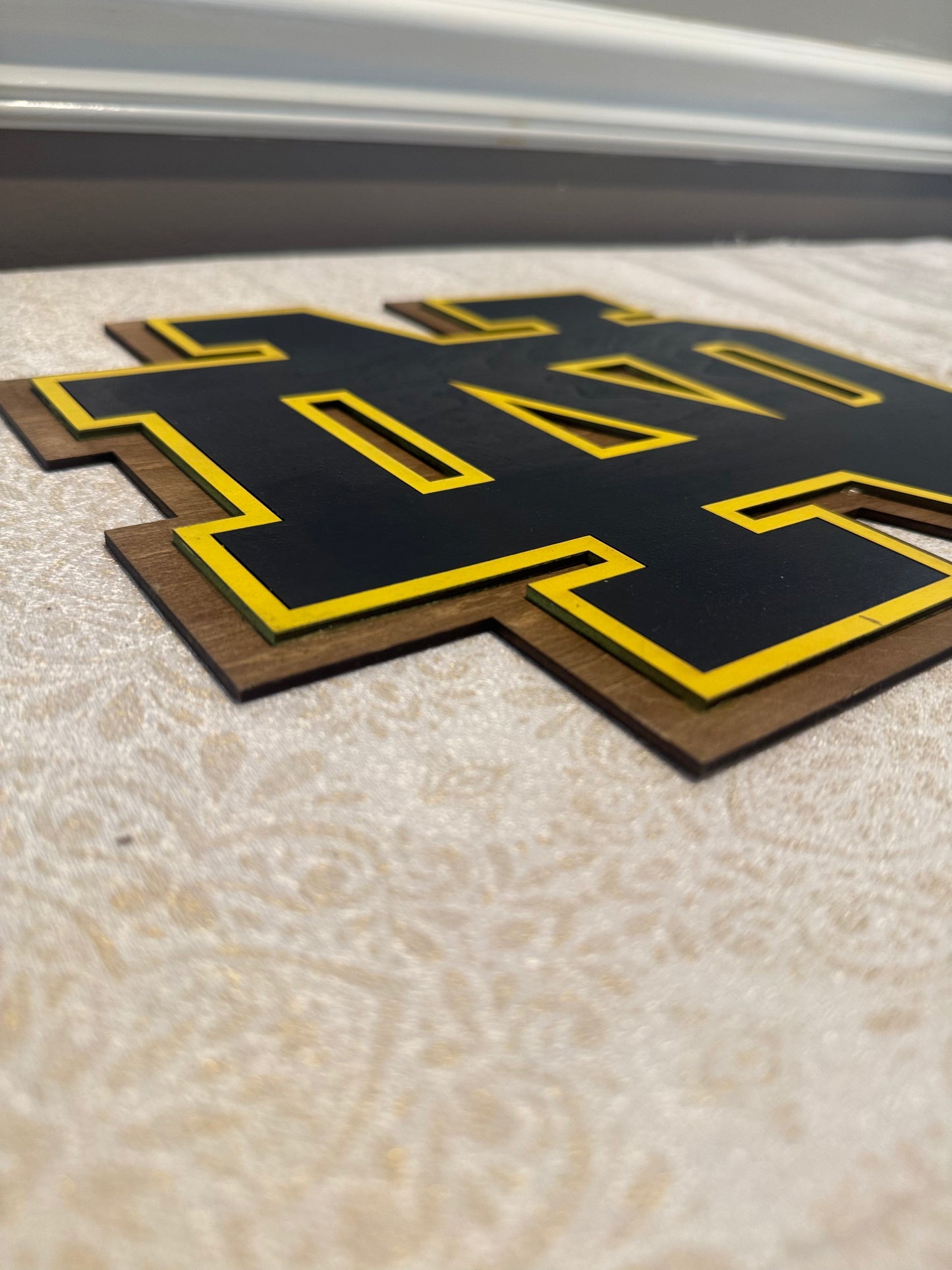 Black and yellow logo on a textured surface