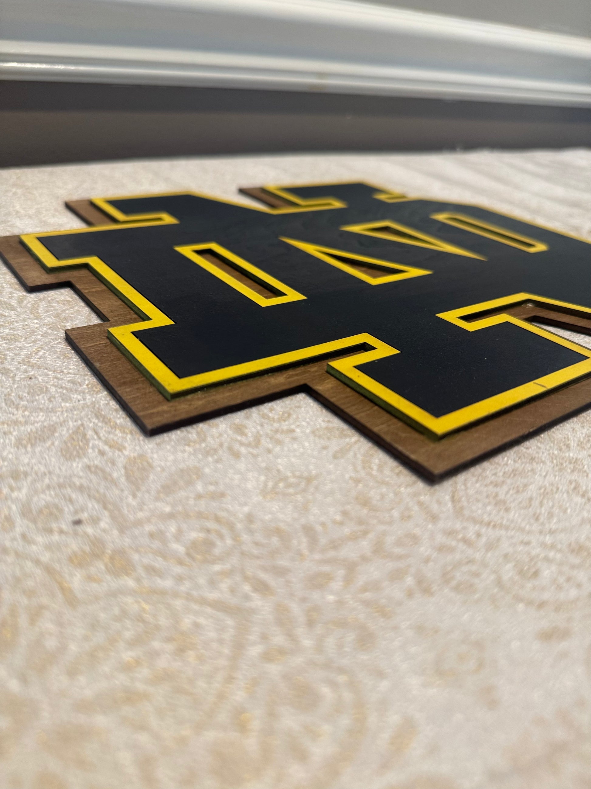 Black and yellow logo on a textured surface