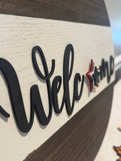 Wooden sign with 'Welcome' text and decorative elements on a blurred background