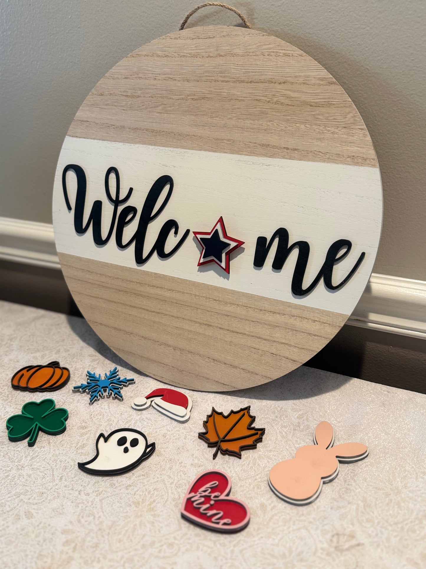 Round wooden sign with 'Welcome' text and decorative cutouts on a neutral background