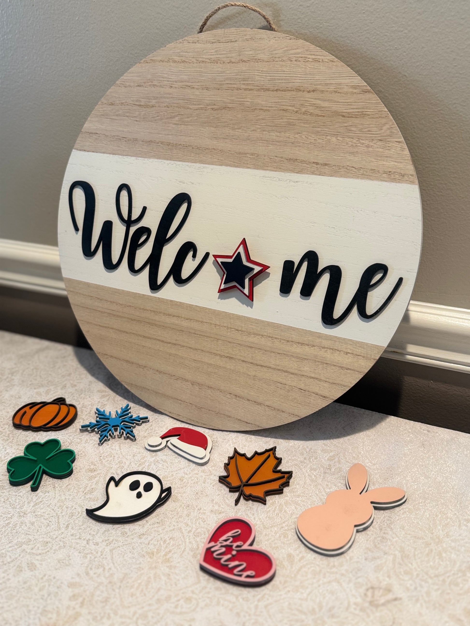 Round wooden sign with 'Welcome' text and decorative cutouts on a neutral background