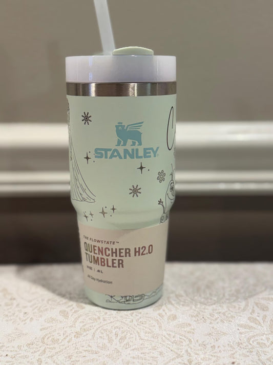 Stanley tumbler with a straw on a textured surface